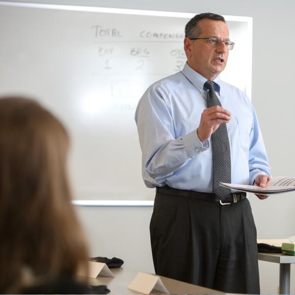 Man Explaining Policies in a Conference Room Setting